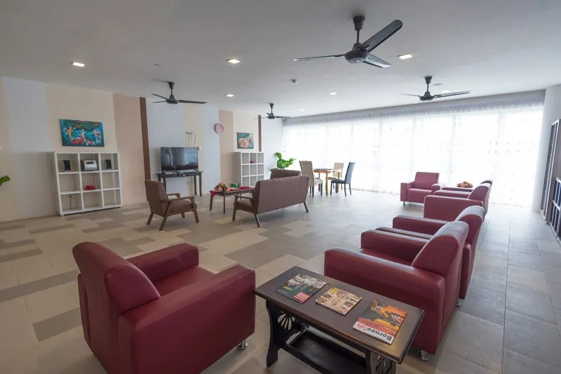 Resident lounge at Eden on the Park with armchairs, tables, and television