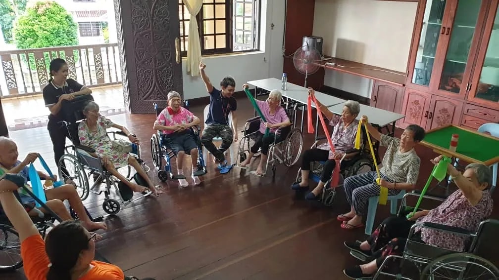 Residents taking part in an indoor band exercise at Premier Elderly