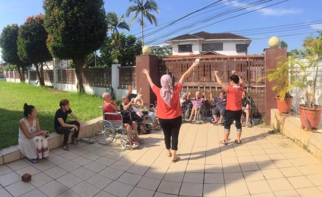 Residents taking part in an outdoor group exercise at Premier Elderly