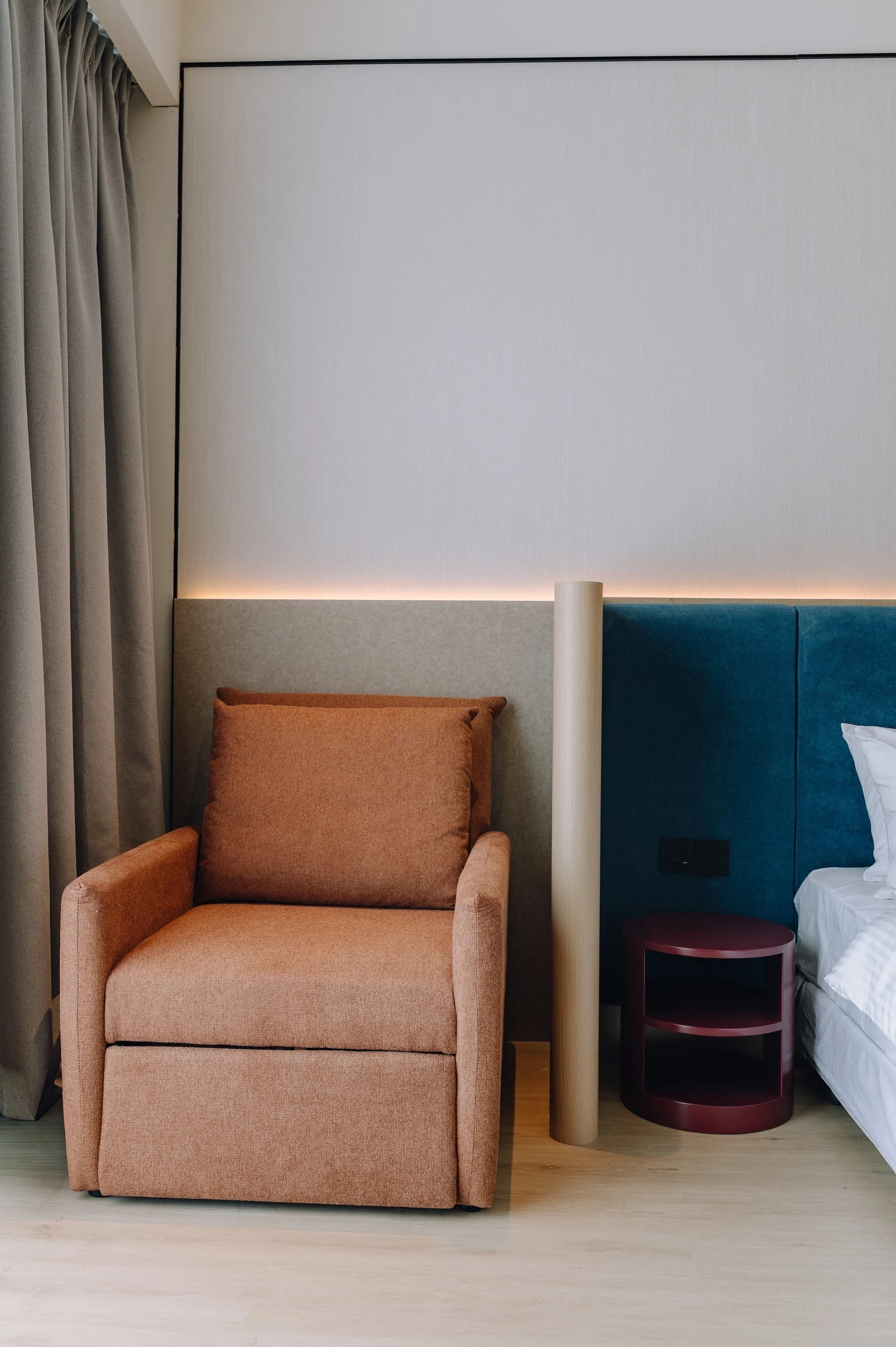 King bedroom at Care Collective with a terracotta armchair beside the bed