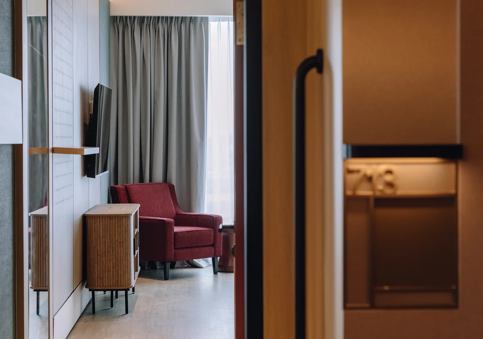 Care Collective lounge with an armchair, television, sideboard, and window