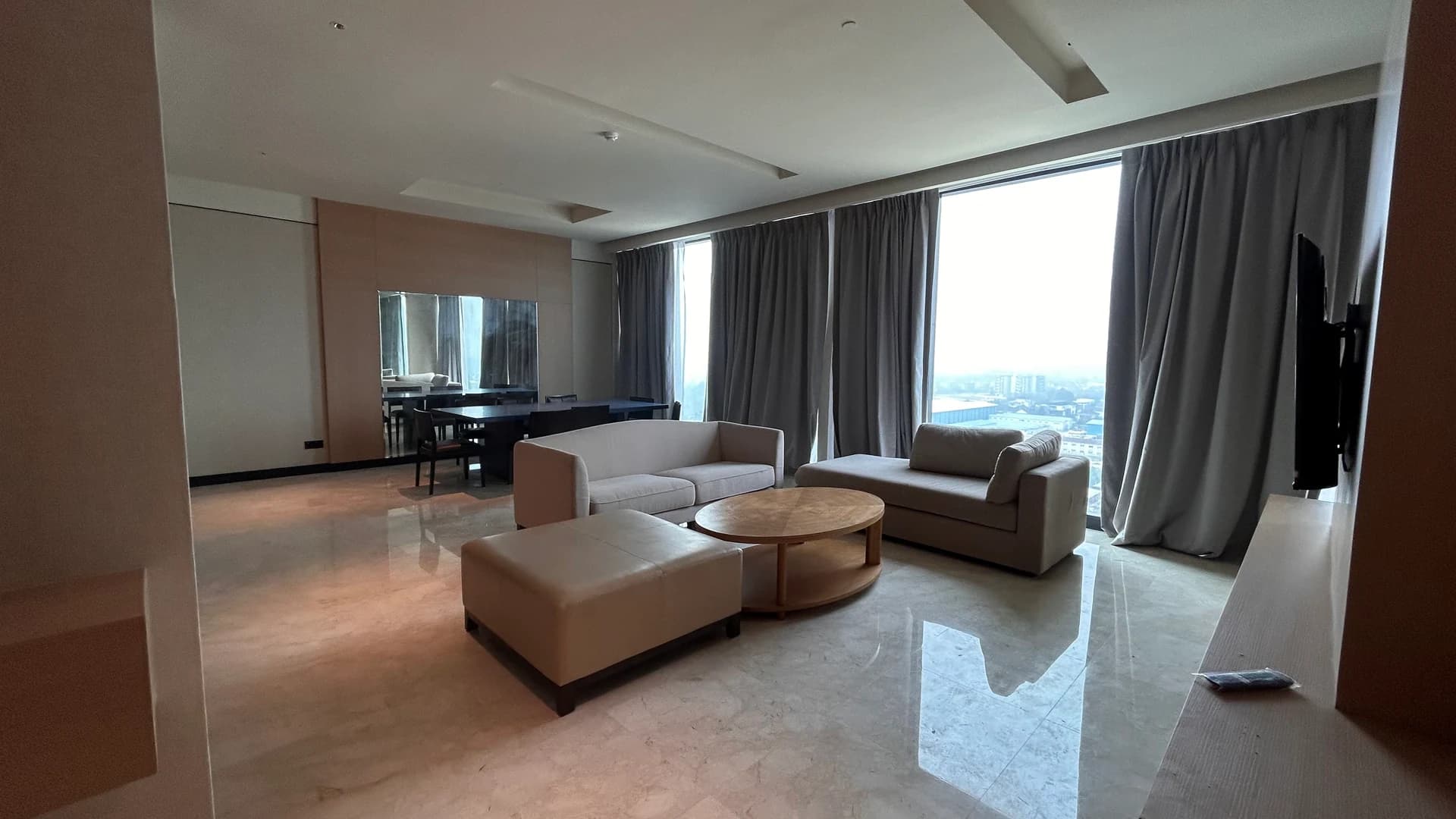 A large suite living area with sofas and wide windows