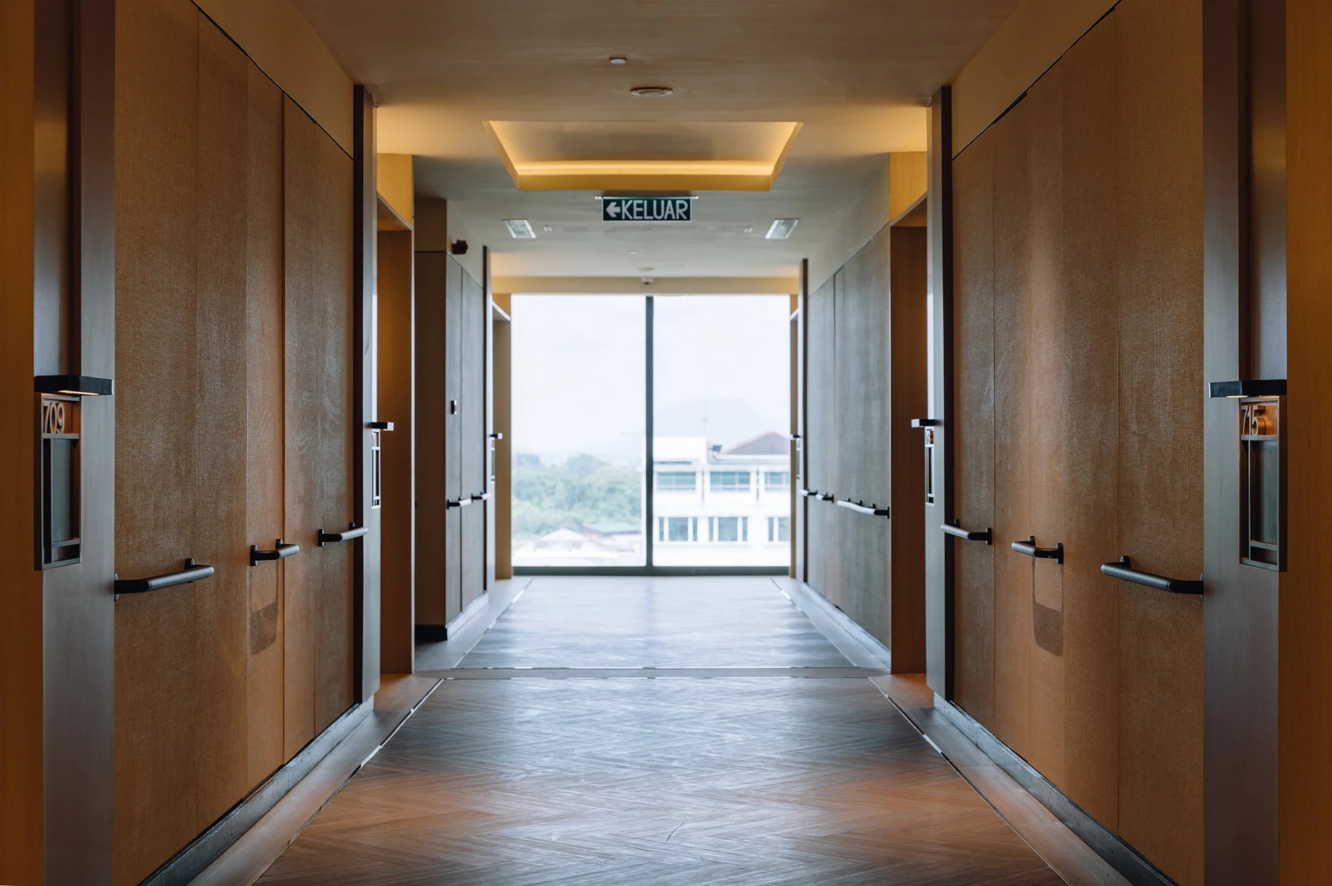 A Care Collective corridor with grab rails along both walls and a window at the far end